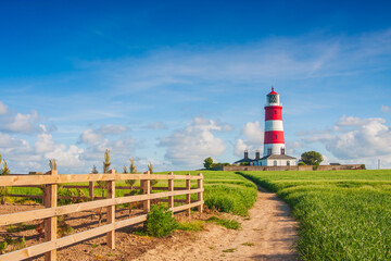 Happisburgh Lighthouse, the oldest working lighthouse on the coast in North Norfolk, UK on a sunny...