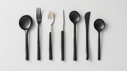 A set of black forks and spoons on a white surface.