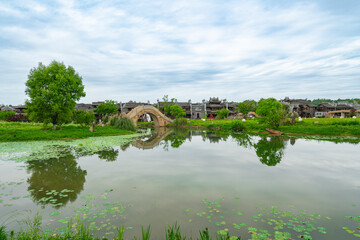 Fototapeta premium The stone arch bridge over the lake in the countryside of the village