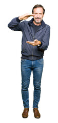 Naklejka premium Middle age handsome man wearing a jacket gesturing with hands showing big and large size sign, measure symbol. Smiling looking at the camera. Measuring concept.