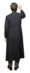 Middle age priest man wearing catholic robe Posing backwards pointing behind with finger hand