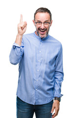 Naklejka premium Middle age hoary senior man wearing glasses over isolated background pointing finger up with successful idea. Exited and happy. Number one.