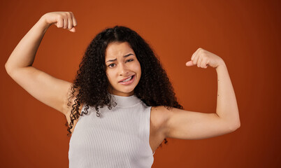 Bicep, flex and portrait of powerful woman in studio isolated on brown background for girl power....