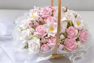 Zephyr bouquet of flowers in a wicker basket on a light background