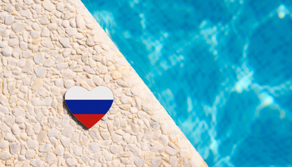 Russian flag in the shape of a heart near a hotel pool.