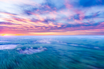 Aerial motion blurred landscape at sunset with intentional camera movement from a fast moving drone.