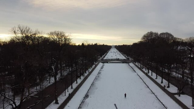 Aerial view of people walking on the fronzen Nymphenburg channel in snow covered city of Munich