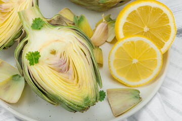 Fresh green artichokes cooking on wooden background. Traditional seasonal ingredients