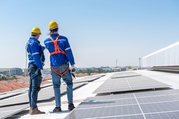 Two solar panel workers installing solar panels on a roof.