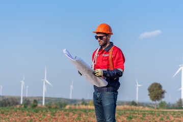 Male man engineer inspection posing check control wind power machine in out door wind energy factory. Young man technician professional worker check wind power machine for maintenance turbine