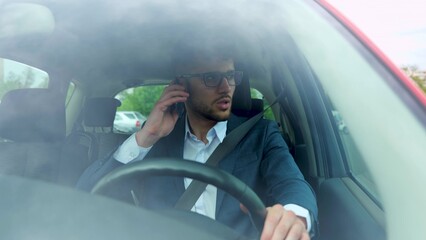 Businessman talking on mobile phone while driving and overtaking, paying attention to the road. Transport, business, technology and people concept. Real time