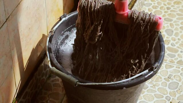 A mop and a bucket of soapy water.