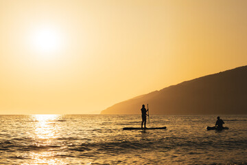 A man is paddling a surfboard in the ocean