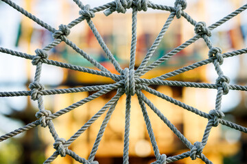 A close up of a web of ropes with a yellow background