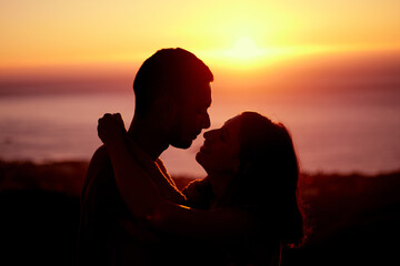 Sunset, sky and silhouette of couple with hug, embrace and orange sunshine on romantic outdoor date. Love, man and woman with care, nature and support for evening adventure, holiday and relationship
