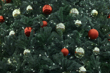 Festive New Year Christmas tree decorated red yellow Christmas balls with garlands lights, close up view, merry Christmas and happy New Year, essence of holiday cheer and joyous spirit