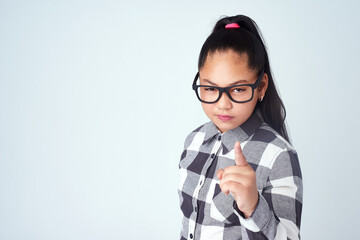 Portrait, finger and girl with attitude, serious face and hand gesture on white studio background....