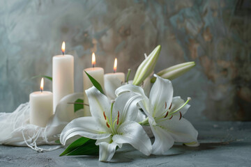 Obraz na płótnie Canvas Peaceful condolence background with white lilies and lit candles on a textured grey surface, symbolizing sympathy and remembrance