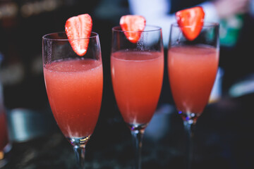 Bartender working, beautiful row line of different coloured liquor alcohol cocktails on a party in a bar, and others on catering banquet on event, barman mixing drinks and beverages in a club