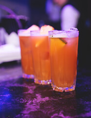 Bartender working, beautiful row line of different coloured liquor alcohol cocktails on a party in a bar, and others on catering banquet on event, barman mixing drinks and beverages in a club
