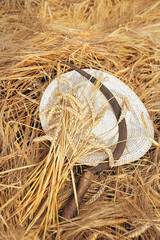 summer Hat, ears wheat and old sickle on field. Wheat field harvest and ripe wheat straws....