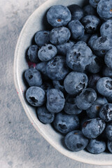 organic blueberries in bowl on gray background