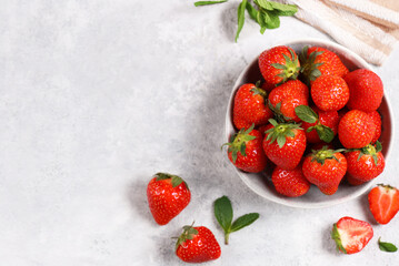 organic strawberries in a bowl on a gray background