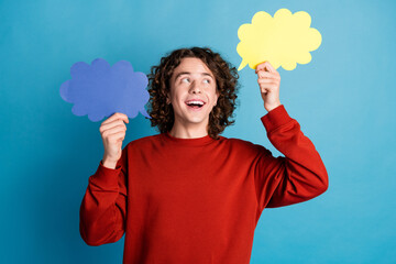 Photo of cheerful positive guy dressed red pullover rising talking bubbles emtpy space isolated...