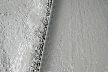  white cement slab with a white line of gravel on it