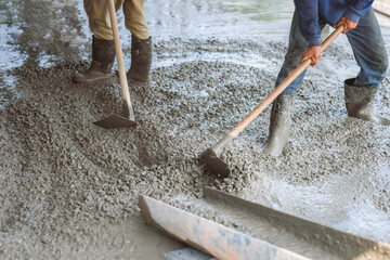 Two men are working on a concrete slab