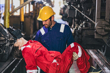  man in a yellow helmet is holding a woman in a red jumpsuit