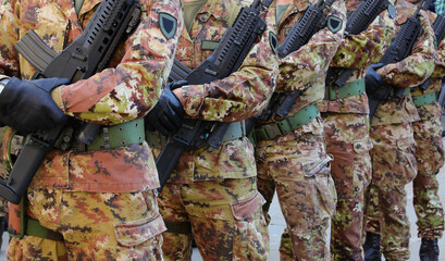 Platoon of soldiers in camouflage uniforms with weapons during the Alpine Rally