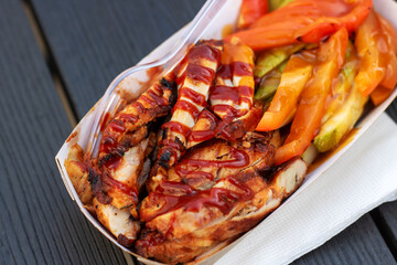 Fast food container with chicken, vegetables, and fork for convenience