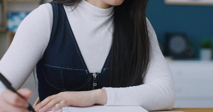 Young woman in glasses using laptop for online study or work. Positive girl studying concentratedly or working remotely at home. Talking with her teacher or executive from video call.