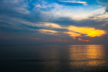 A calming sunrise on a North Sumatran beach with views of the Malacca Strait and fishermen from afar.