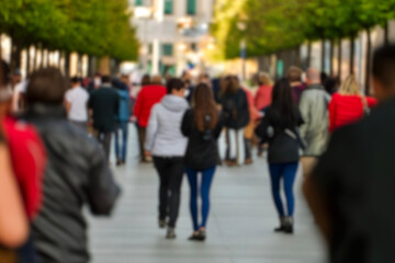 blurred for background. Crowd of people on the street. people walking on the city street. A blurry people walking. Urban, social concept. Abstract urban background with blurred buildings and street.