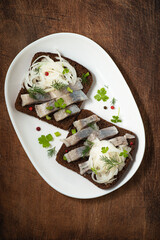 Herring dish: Smorrebrod with herring - toasted  rye  bread with spicy salted fish with pepper,...