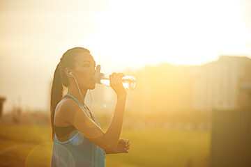 Woman, runner and drinking water with earphones for exercise with audio, subscription or detox in...