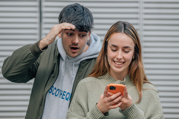 couple spying and looking at mobile phone
