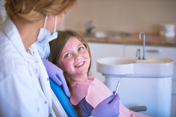 Smile, girl and dentist with dental checking with oral hygiene and teeth care with patient and...