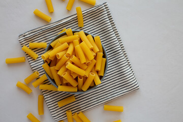 Dry Rigatoni Pasta in a Bowl, top view. Flat lay, overhead, from above. Space for text.
