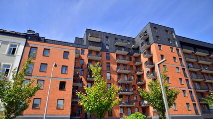 Modern residential building with new apartments in a green residential area. Eco architecture. Green tree and new apartment building. The harmony of nature and modernity.