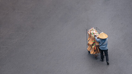 Aerial view Vietnamese street vendor pulls a cart with food along a quiet road