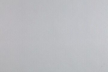 Background of gray evenly textured paper wallpaper. Gray plastered wall.