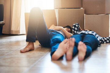 Couple, floor and relax in new home with boxes for property investment and moving day for...
