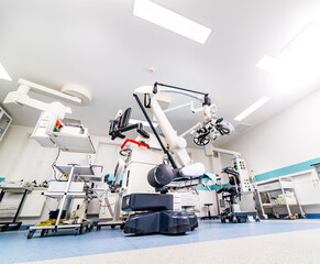 A hospital room with a robot in the middle. The robot is surrounded by medical equipment and is in...