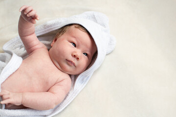 Little cute Caucasian baby girl in a white towel with a hood after a bath. Newborn 6 week old baby...
