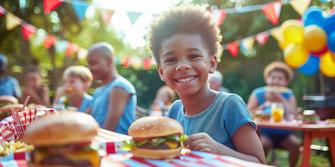 The image of a small African-American boy sitting at the dining table and eating hamburgers with an appetite reflects the idea of celebrating U.S. Independence Day, which is celebrated on July 4.
