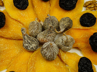 Composition of dried fruits and nuts in the shape of a flower. Dried mango slices, prunes and figs,...