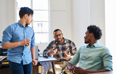 Collaboration, conversation and men in modern office for meeting with support, startup agency and brainstorming. Team, discussion and planning for ideas by desk for advertising project and feedback